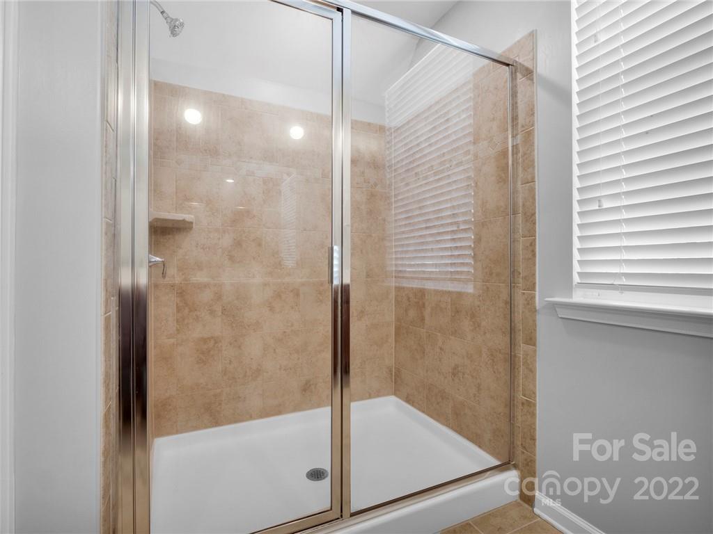 10502 Ebbets Road Charlotte, NC 28273 - Photo 40 of 48 a bathroom with a glass shower door