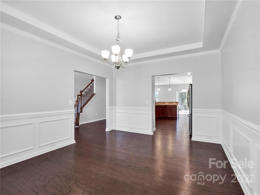 10502 Ebbets Road Charlotte, NC 28273 - Photo 6 of 48 a view of a hallway with wooden floor and chandelier
