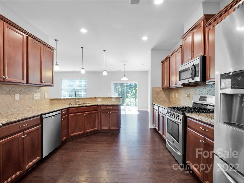 10502 Ebbets Road Charlotte, NC 28273 - Photo 9 of 48 a large kitchen with stainless steel appliances granite countertop wooden cabinets a stove a sink and a granite counter tops