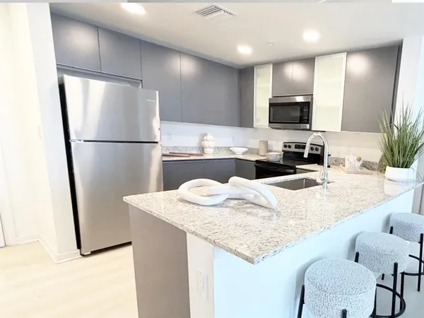 a kitchen with stainless steel appliances granite countertop a sink refrigerator and microwave