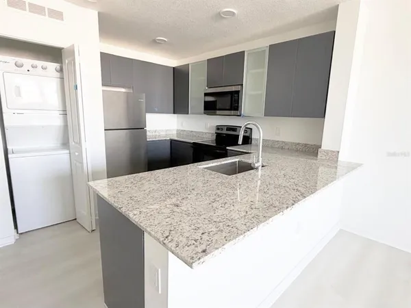a kitchen with stainless steel appliances granite countertop a refrigerator and a sink