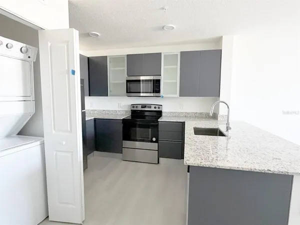 a kitchen with stainless steel appliances granite countertop a stove a sink and a refrigerator