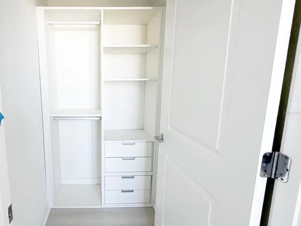 a view of walk in closet with empty racks