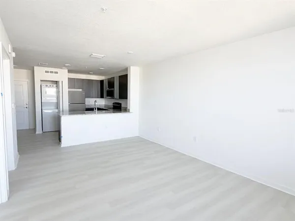 a view of a kitchen with a sink and a refrigerator