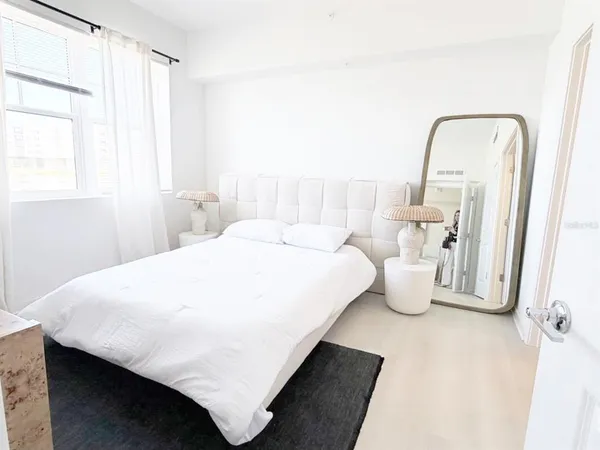 a large bed sitting in a bedroom next to a window