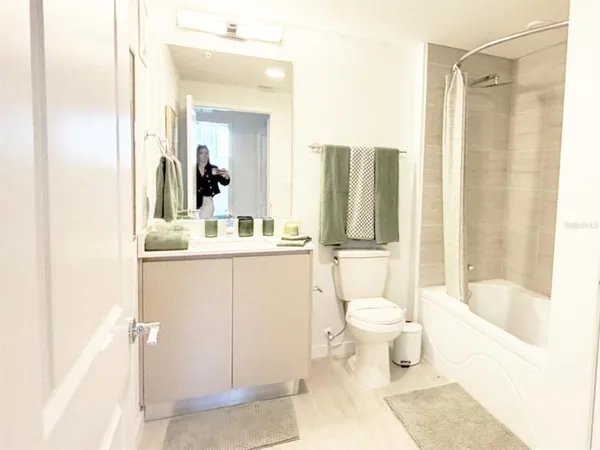 a bathroom with a sink vanity mirror and toilet