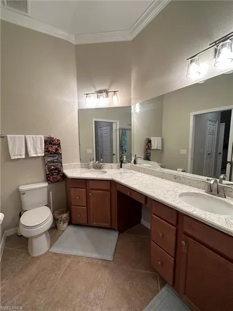a bathroom with a double vanity sink and a toilet