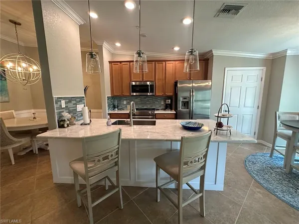 a kitchen with a dining table chairs and sink