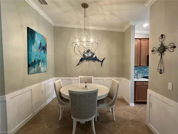 a dining room with furniture a chandelier and window