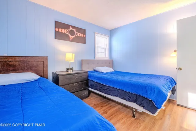 a bedroom with two beds and a lamp