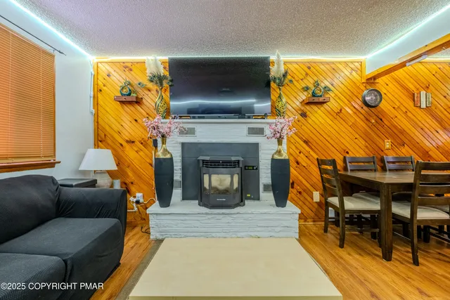 a living room with furniture a fireplace and a flat screen tv