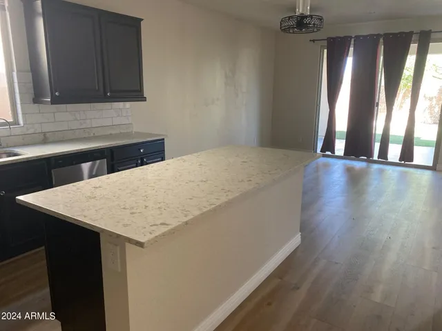 a kitchen with a wooden floor and a window