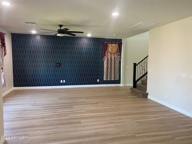 an empty room with wooden floor and entryway