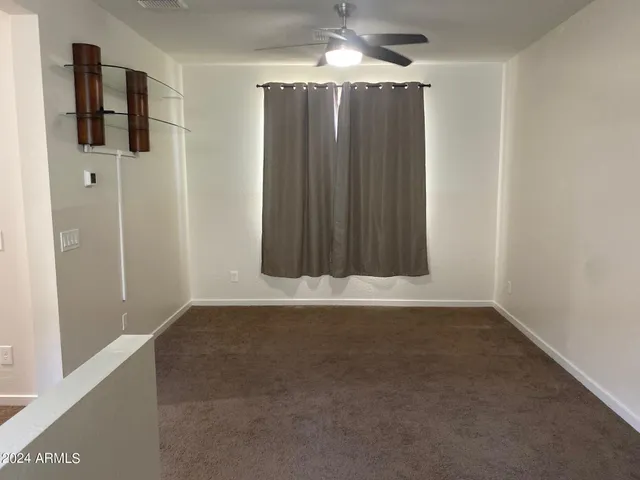 en empty room with wooden floor and windows
