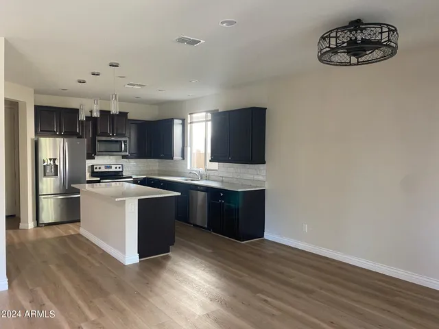 a kitchen with a refrigerator and a stove top oven