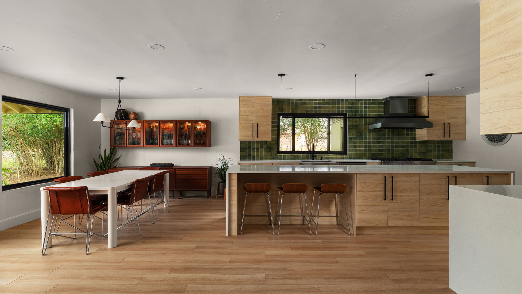 Kitchen featuring modern cabinets, a kitchen breakfast bar, pendant lighting, tasteful backsplash, and light stone countertops