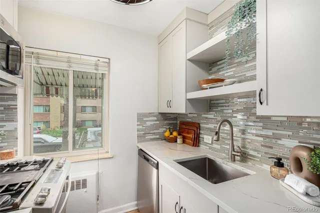 a kitchen with a sink a stove and cabinets