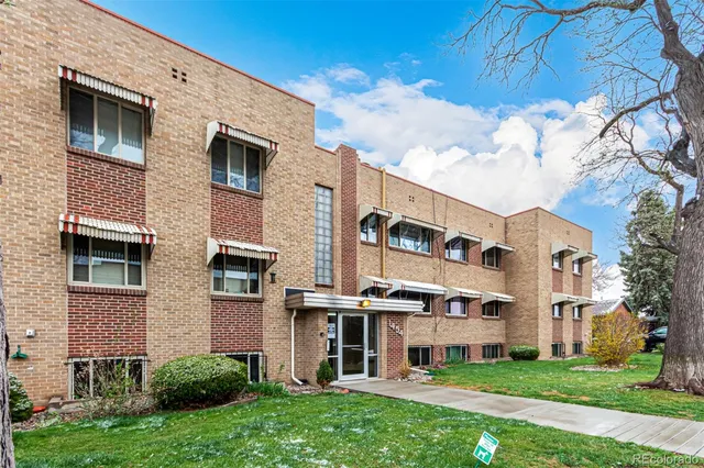 a front view of a building with a garden