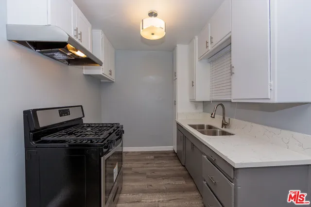 a kitchen with stainless steel appliances granite countertop a sink stove and cabinets