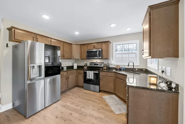 a kitchen with granite countertop a refrigerator and a sink