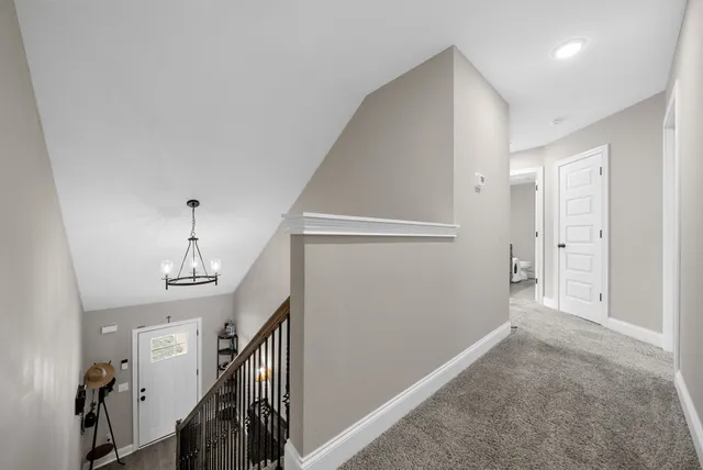 a view of hallway with stairs and wooden floor