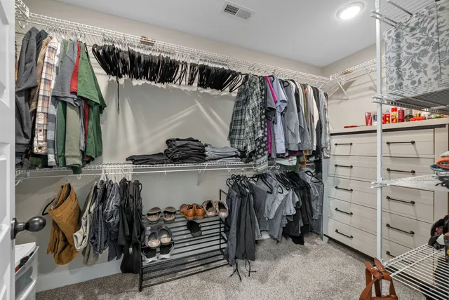 a view of walk in closet with clothes and shoes