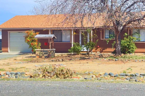 a front view of house with yard covered in snow