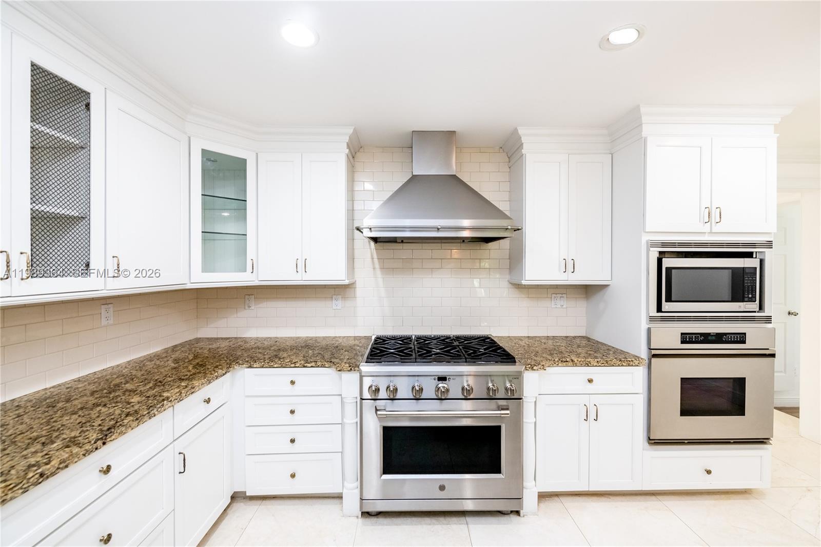 4160 Bay Point Road Miami, FL 33137 - Photo 17 of 60 a kitchen with granite countertop a stove a sink and a microwave