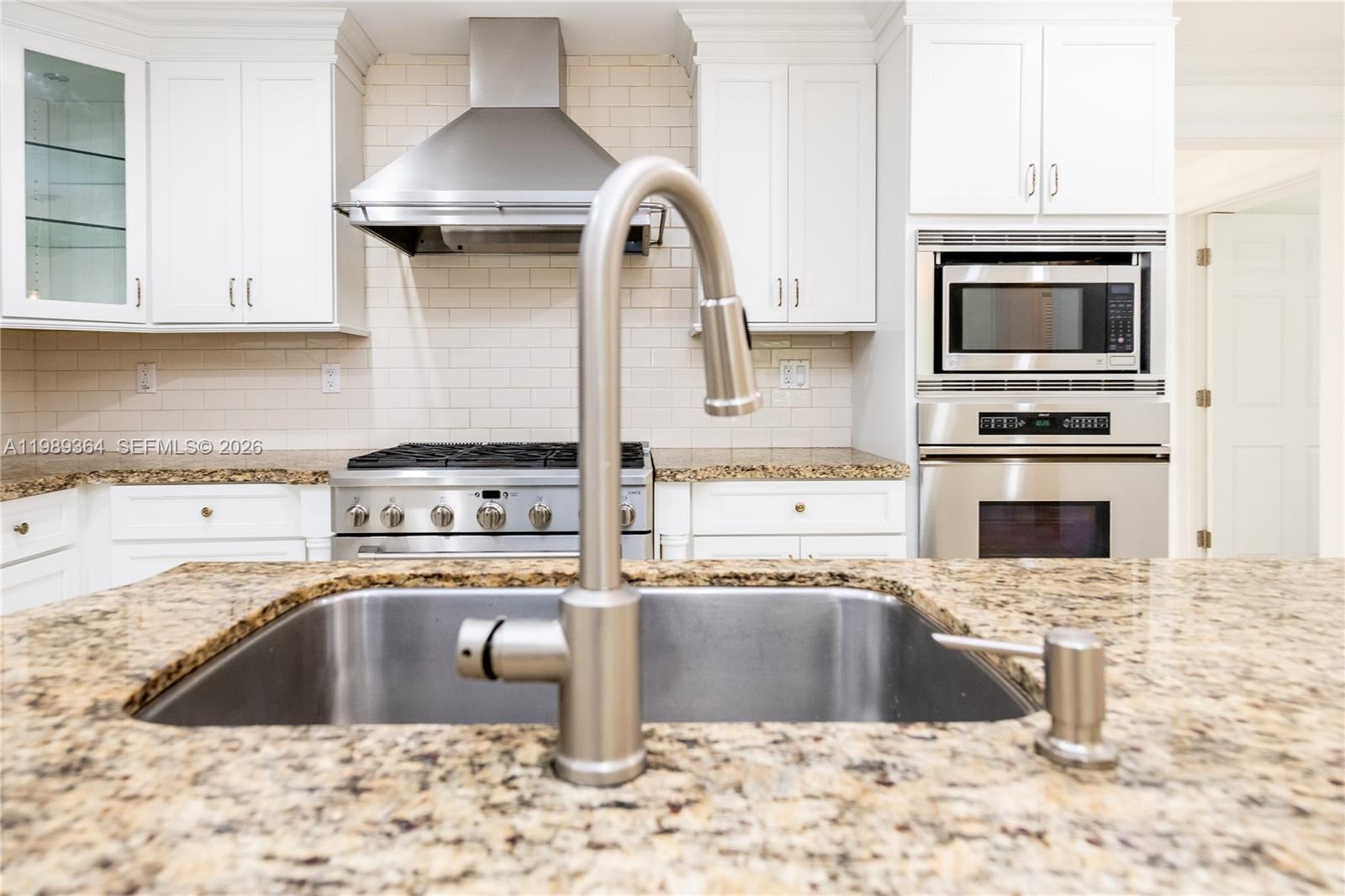 4160 Bay Point Road Miami, FL 33137 - Photo 18 of 60 a kitchen with granite countertop a stove and a sink