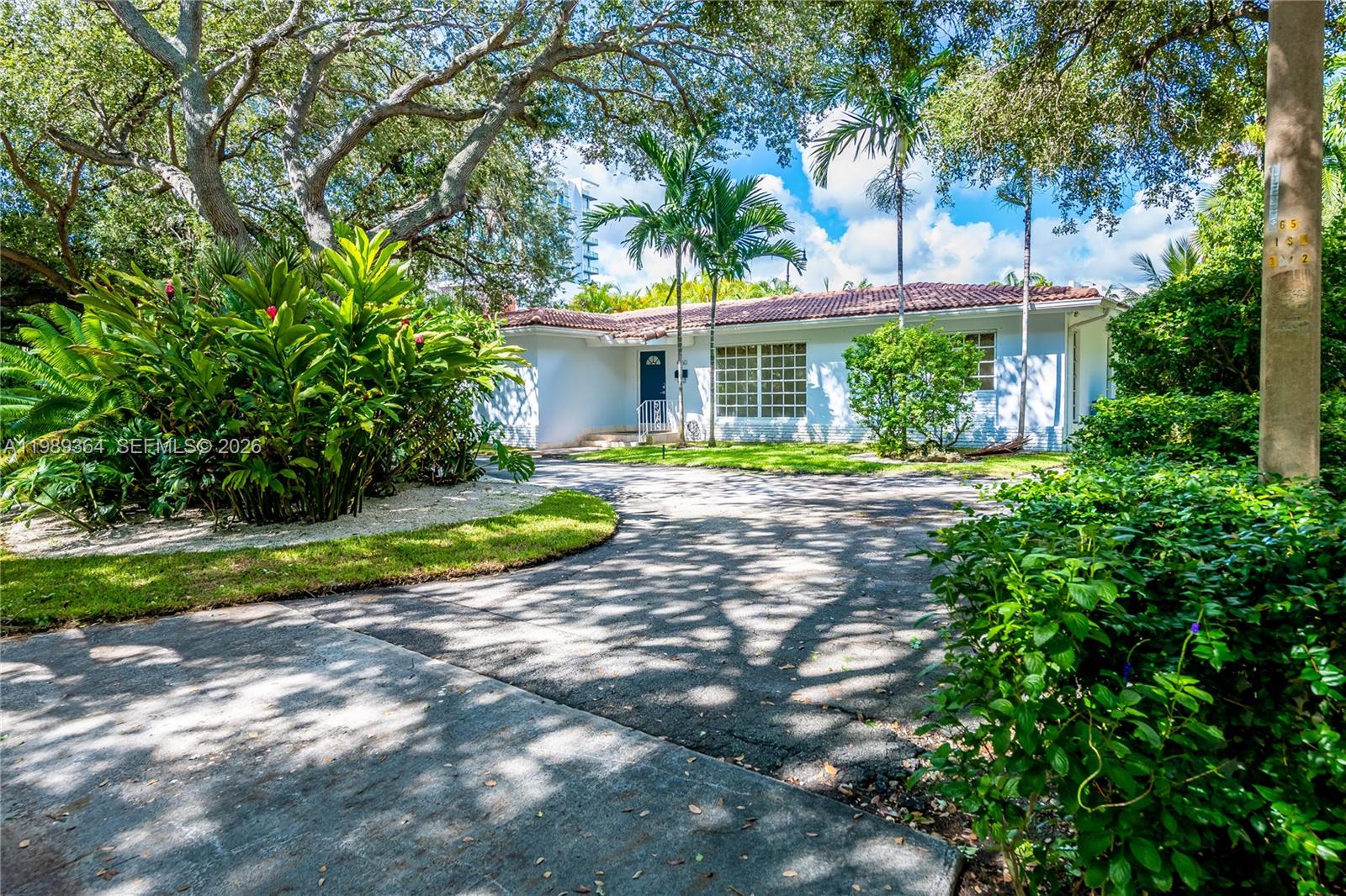 4160 Bay Point Road Miami, FL 33137 - Photo 3 of 60 a view of a house with a yard and palm trees