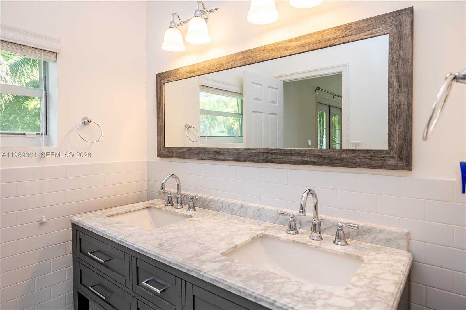 4160 Bay Point Road Miami, FL 33137 - Photo 32 of 60 a bathroom with a granite countertop sink a large mirror and