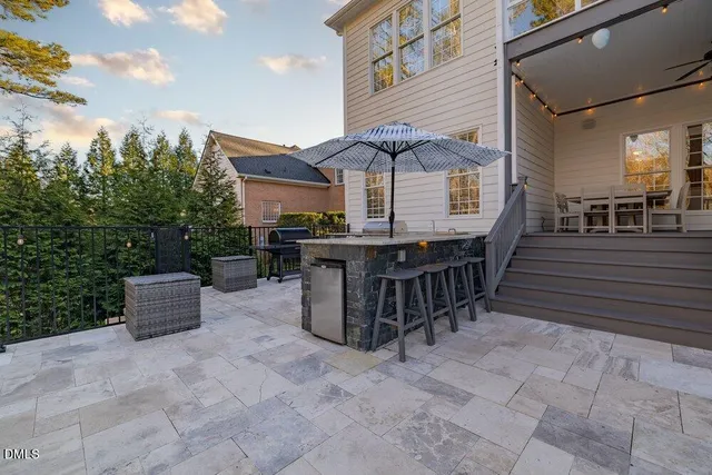 a front view of a house with a garden and lake view