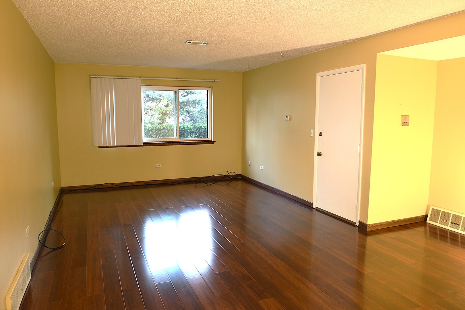 1472 Carol Court, Unit 1A Palatine, IL 60074 - Photo 6 of 11 a view of an empty room with wooden floor and a window