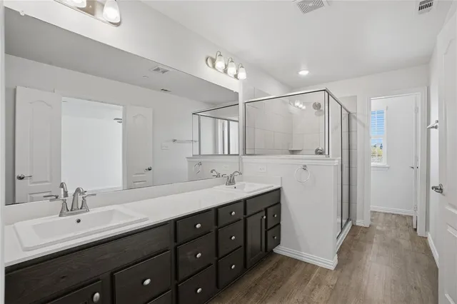 a bathroom with a double vanity sink mirror and shower