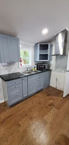 a kitchen with stainless steel appliances granite countertop a sink stove and cabinets