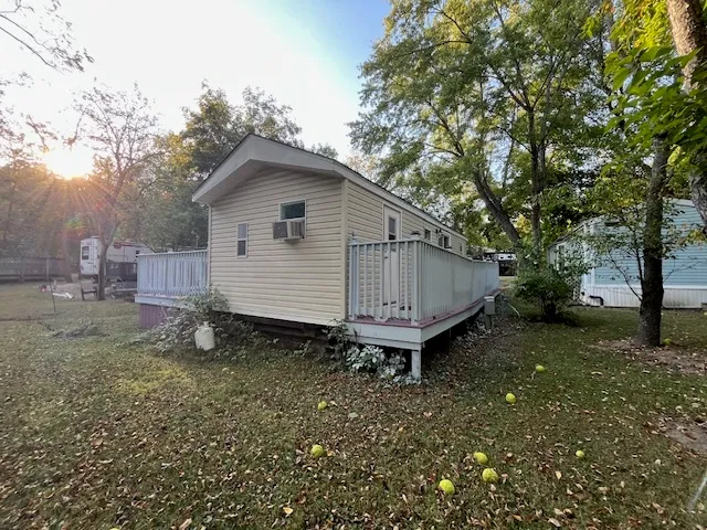 a view of a balcony with wooden floor and fence and a pot