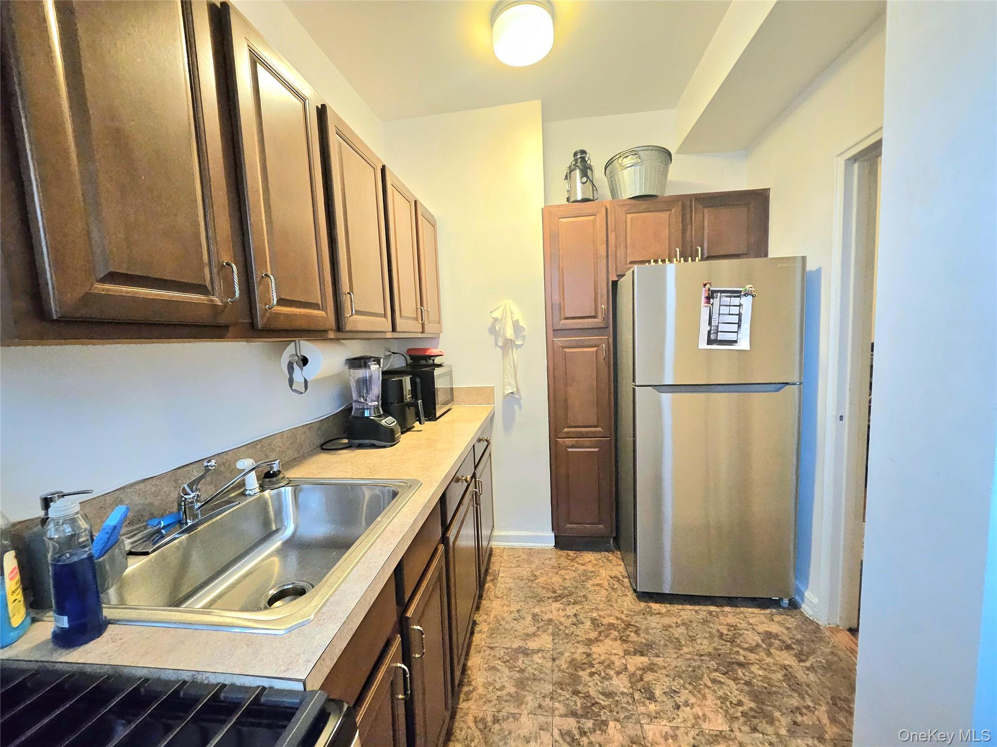 112-25 34th Avenue, Unit H Queens, NY 11368 - Photo 11 of 20 a kitchen with stainless steel appliances granite countertop a refrigerator a sink and a stove