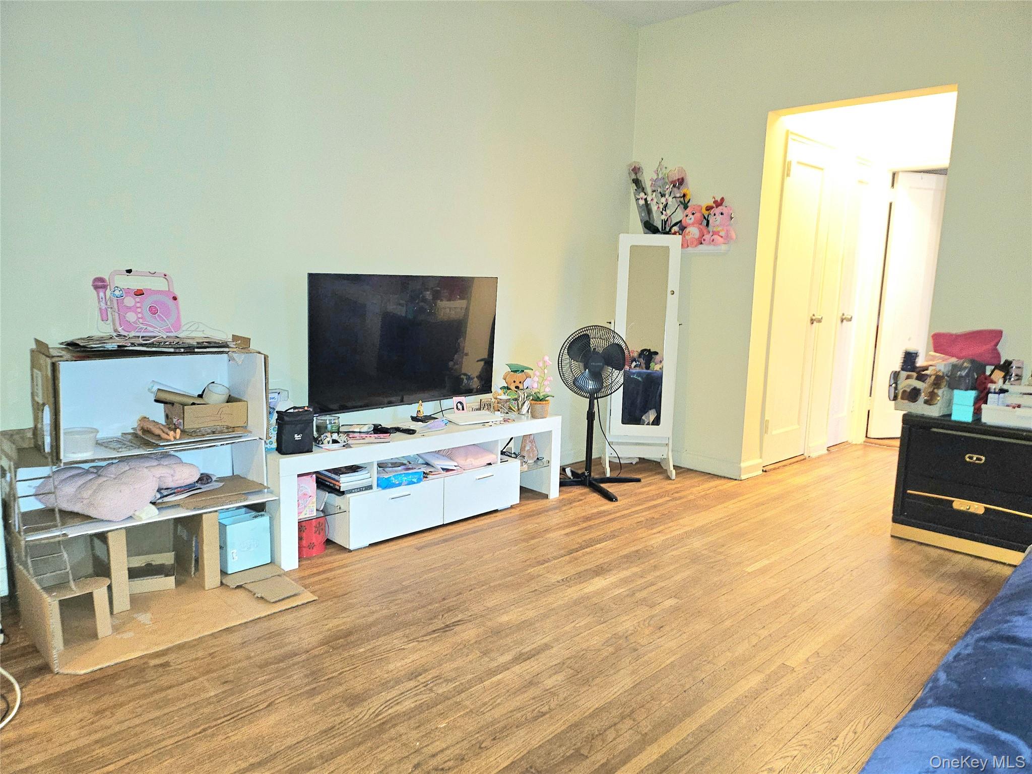 112-25 34th Avenue, Unit H Queens, NY 11368 - Photo 14 of 20 a living room with furniture and a flat screen tv