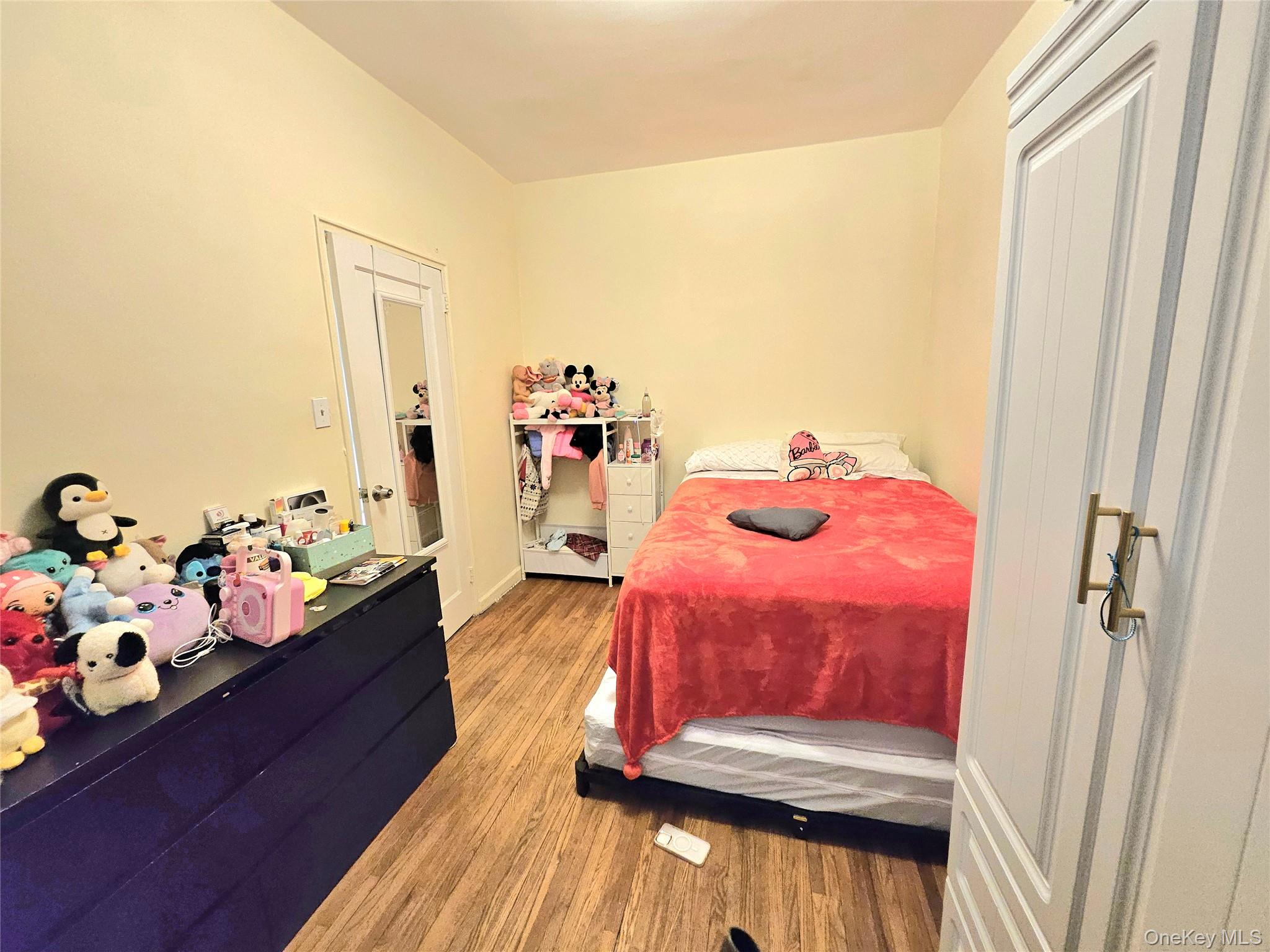 112-25 34th Avenue, Unit H Queens, NY 11368 - Photo 18 of 20 a living room with furniture and wooden floor