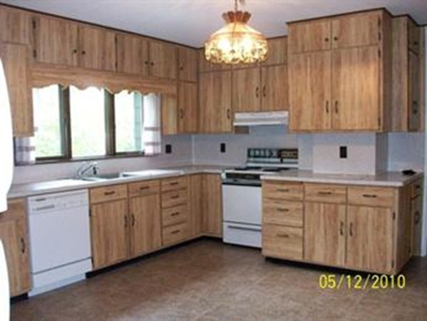 22 Groton-Harvard Road Ayer, MA 01432 - Photo 4 of 6 a kitchen with granite countertop white cabinets a sink dishwasher and a stove with wooden floor