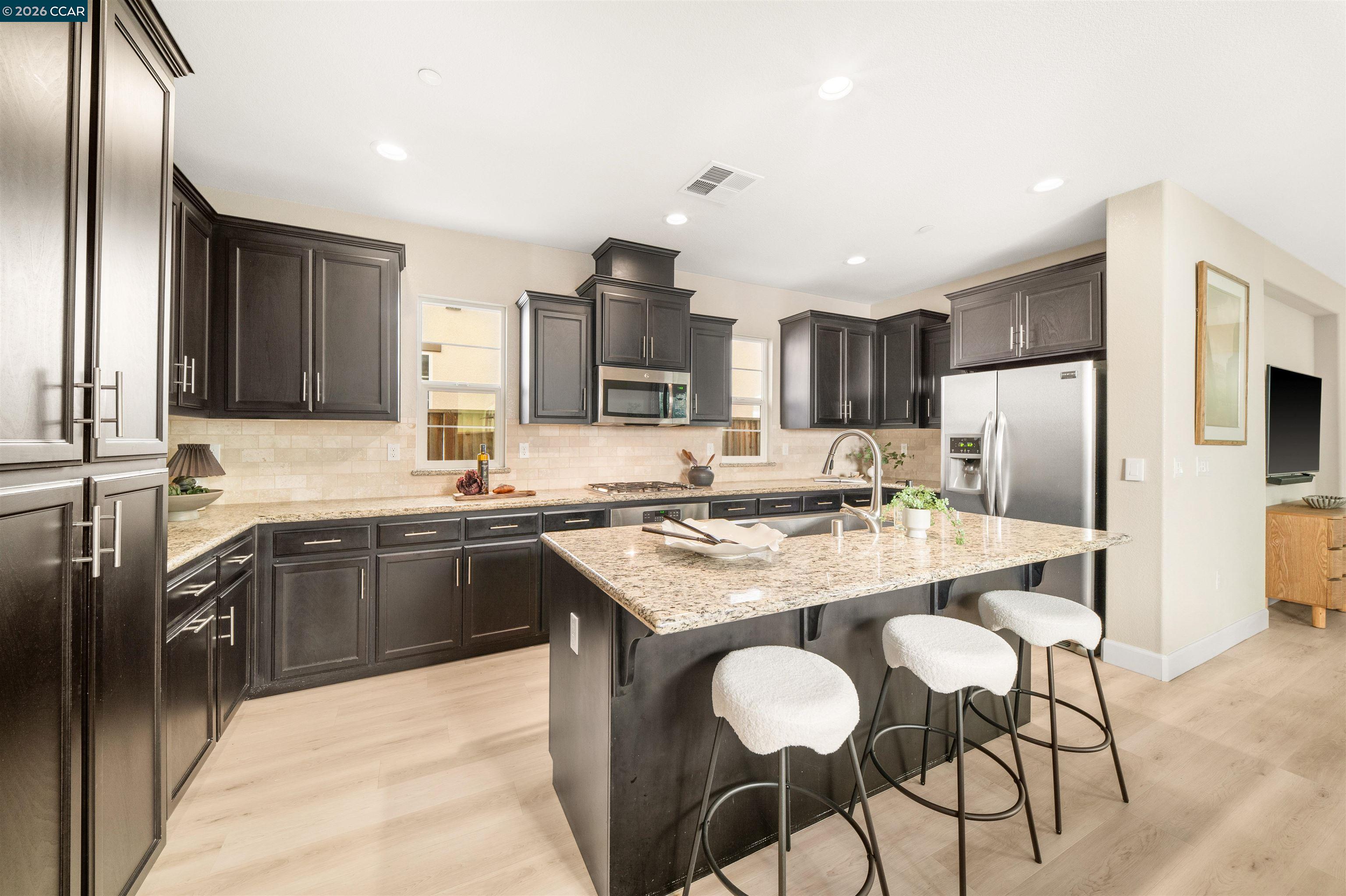 2026 Poinsettia Street San Ramon, CA 94582 - Photo 10 of 26 a kitchen with stainless steel appliances granite countertop a table chairs sink refrigerator and microwave