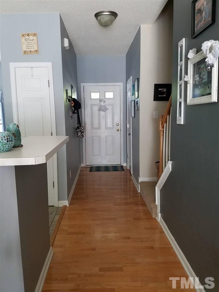 5462 Patuxent Drive Raleigh, NC 27616 - Photo 4 of 25 a hallway view with stainless steel appliances granite countertop a refrigerator and a sink