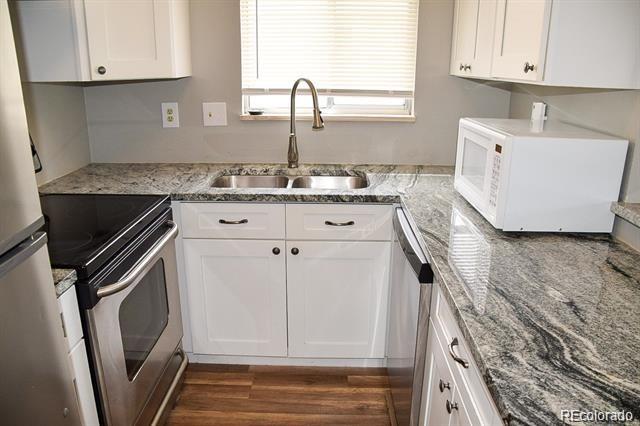 1225 South Oneida Street, Unit 252 Denver, CO 80224 - Photo 7 of 20 a kitchen with a sink stove and cabinets