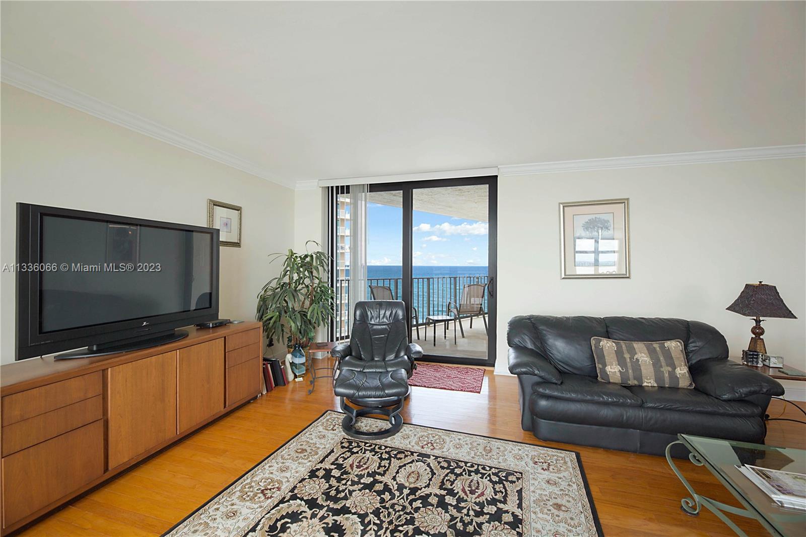 5420 North Ocean Drive, Unit 1205 Riviera Beach, FL 33404 - Photo 12 of 76 a living room with furniture and a flat screen tv