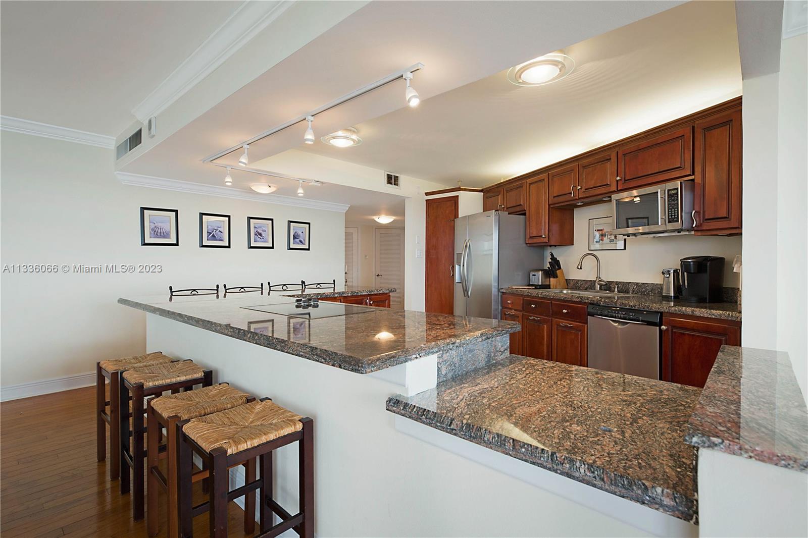 5420 North Ocean Drive, Unit 1205 Riviera Beach, FL 33404 - Photo 15 of 76 a large kitchen with stainless steel appliances granite countertop a large counter top and a stove