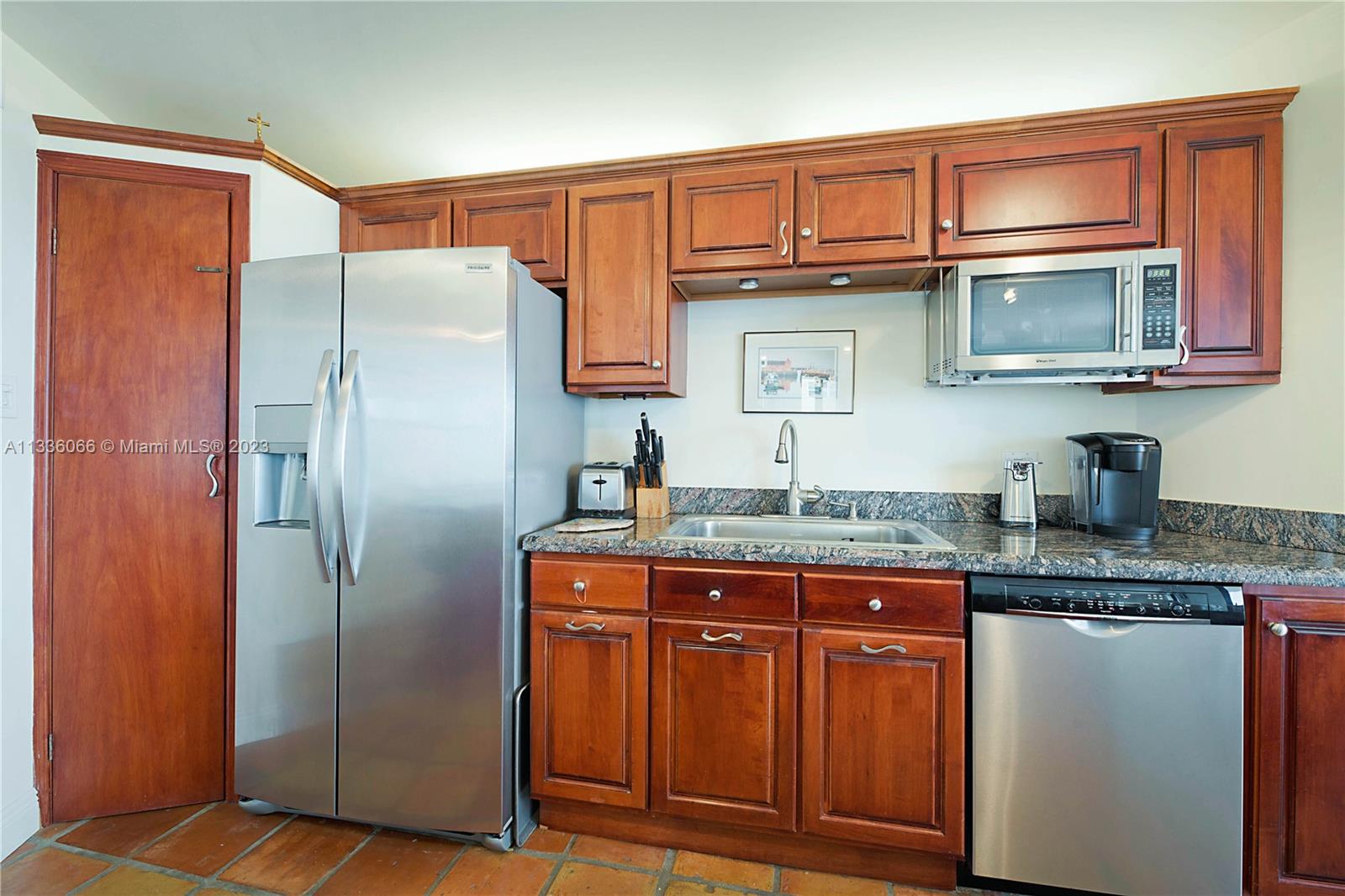5420 North Ocean Drive, Unit 1205 Riviera Beach, FL 33404 - Photo 17 of 76 a kitchen with granite countertop a refrigerator and a sink