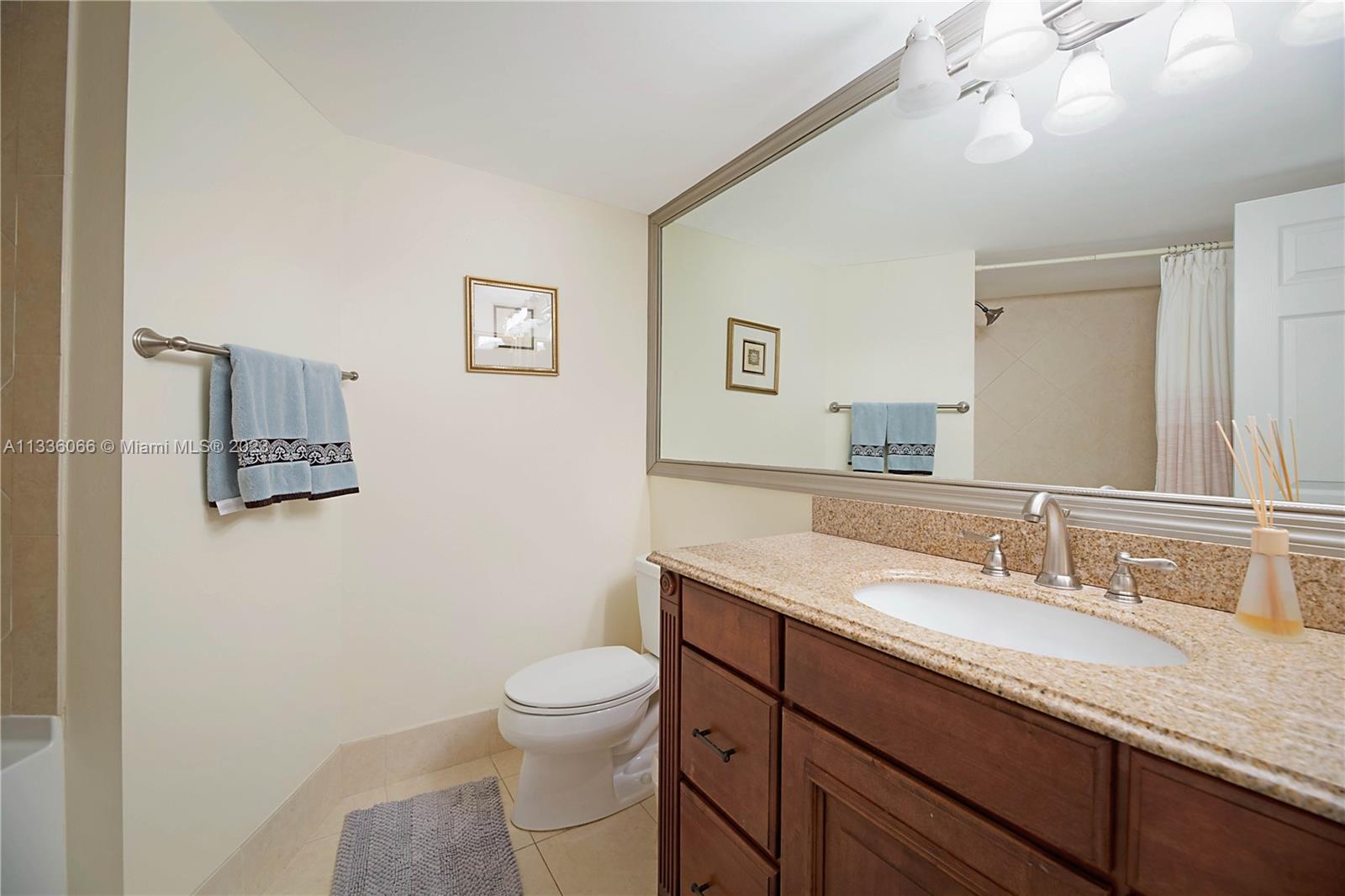 5420 North Ocean Drive, Unit 1205 Riviera Beach, FL 33404 - Photo 22 of 76 a bathroom with a granite countertop sink a mirror and toilet