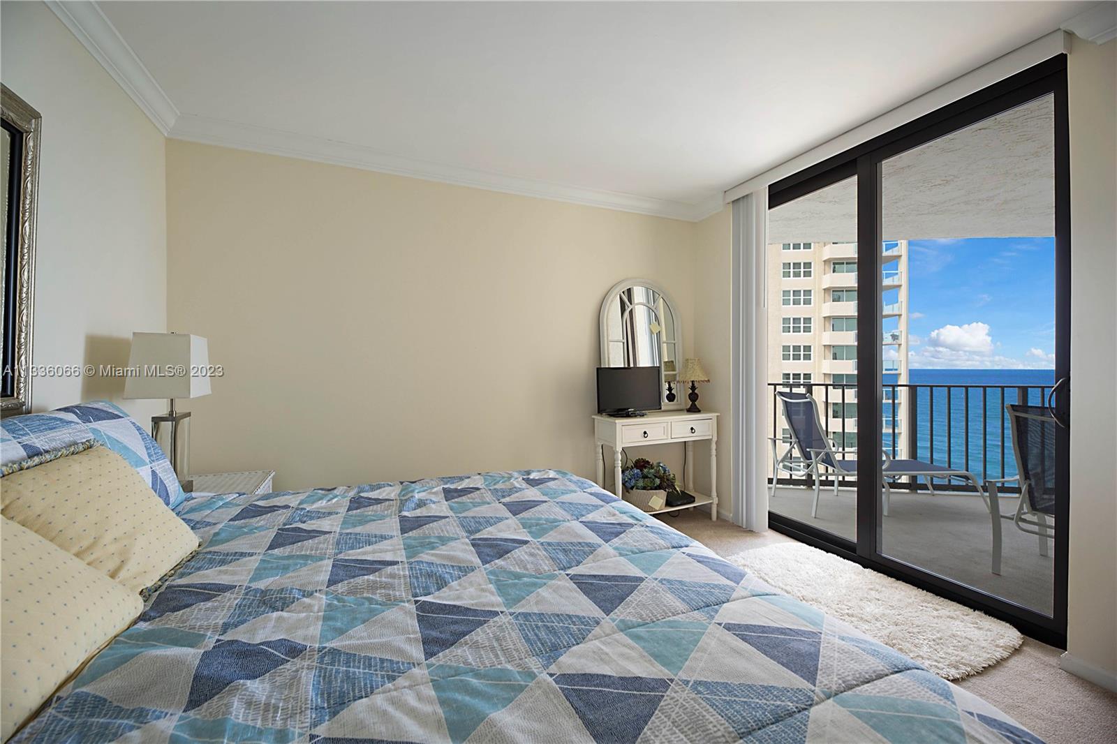 5420 North Ocean Drive, Unit 1205 Riviera Beach, FL 33404 - Photo 24 of 76 a bedroom with a bed and a lamp on table