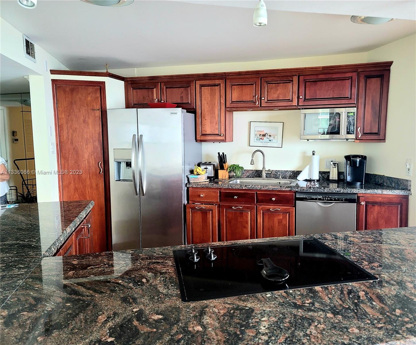 5420 North Ocean Drive, Unit 1205 Riviera Beach, FL 33404 - Photo 35 of 76 a kitchen with stainless steel appliances granite countertop a refrigerator and a sink