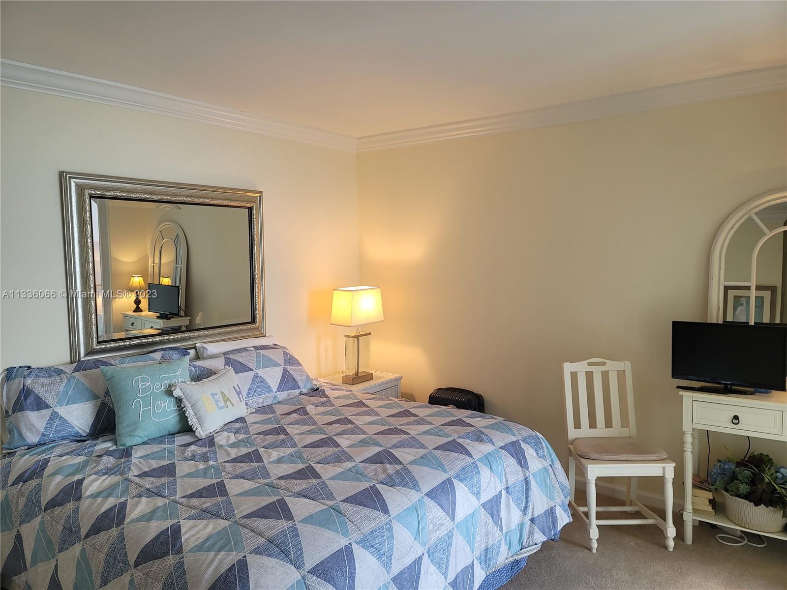 5420 North Ocean Drive, Unit 1205 Riviera Beach, FL 33404 - Photo 43 of 76 a bedroom with a bed and flat screen tv